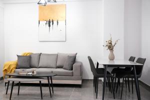 a living room with a couch and tables at Cozy Home With Cooking in Piraeus