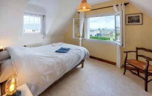 ein Schlafzimmer mit einem Bett, einem Fenster und einem Stuhl in der Unterkunft Nice Home In Plouguerneau With Wifi in Plouguerneau + 29 Fotos