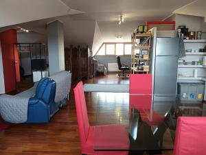 a living room with pink and blue chairs and a refrigerator at Mansarda Open Space in Ciampino