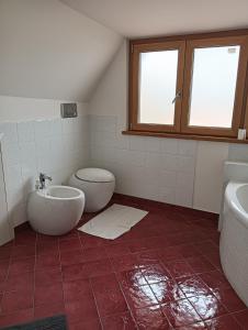 a bathroom with a toilet and a sink and a tub at Mansarda Open Space in Ciampino +3 photos