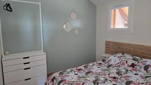 a bedroom with a bed and a dresser and a window at Appartement moderne et cosy in Bartenheim