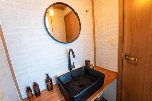 a bathroom with a black sink and a mirror at The BONDS オーシャンフロントヴィラー千葉いすみー in Kobama +15 photos