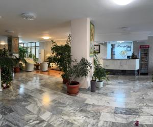 Un vestíbulo con plantas en macetas en un edificio. en Apart Hotel Central Razgrad, en Razgrad