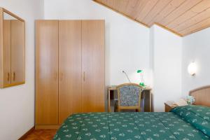 1 dormitorio con 1 cama, armario y escritorio en cèsa Maria Suen, en Canazei 47 fotos más