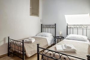 two beds in a room with white walls at Casa Teresa con vista in Modica