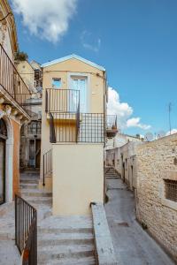 eine Gasse mit Treppen, die zu einem Gebäude hinaufführen in der Unterkunft Casa Teresa con vista in Modica