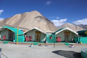 a group of tents with a mountain in the background at Martsemik Camping Spangmik in Chimre