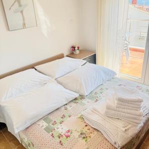 a bed with white sheets and towels on it at Luxury Apartments Villa Lenka in Podstrana