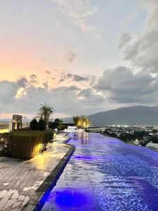 a pool with blue and purple lights in the water at Astra Sky River 5 Stars Pool Sauna Gym in Chiang Mai