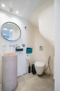 a bathroom with a toilet and a mirror at Skepi Town Houses in Mikonos +12 photos