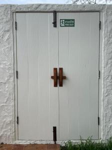 a white garage door with two crosses on it at Turtle Tales-Tahnu,Thaimueang beach,Phang-Nga in Thai Muang