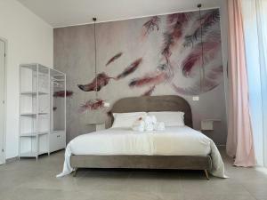 una camera da letto con un grande letto con uccelli sul muro di Siracusa Centro a Siracusa