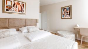 a white bedroom with a bed and a desk at Casa Lei by Villas Holiday in Malinska +22 photos