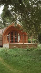 a small house with a large window in a yard at Carlton Manor pods in Aldbrough +11 photos