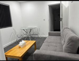 a living room with a couch and a table at 1 Bed Flat - Sleeps 2 - Parking - Wifi in Luton