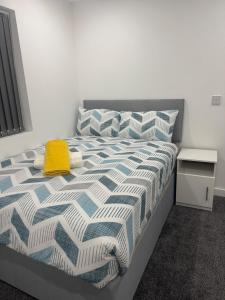 a bedroom with a bed with a yellow towel on it at 1 Bed Flat - Sleeps 2 - Parking - Wifi in Luton