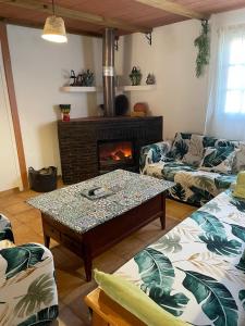 a living room with a table and a fireplace at Cortijo Luz de la Sierra in Dúdar +21 photos