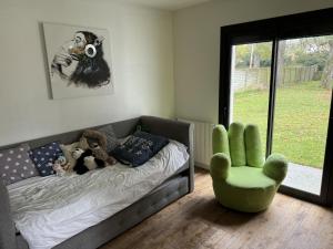 a bedroom with a bed with stuffed animals and a chair at Maison familiale LA ROCHELLE in LʼHoumeau +2 photos