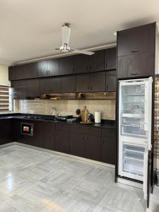 a kitchen with dark brown cabinets and an open refrigerator at B4 Rentals in Ajiringano