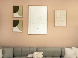 a living room with a couch and four framed pictures at Wabi-Sabi Style Fountain-View 4 BR Apt in the Sky in Dubai