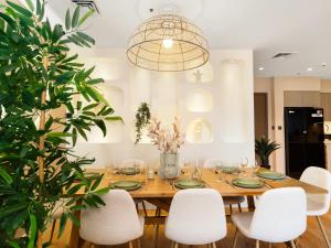 a dining room with a wooden table and white chairs at Wabi-Sabi Style Fountain-View 4 BR Apt in the Sky in Dubai