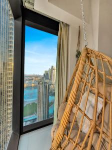 a hanging hammock in a room with a large window at Wabi-Sabi Style Fountain-View 4 BR Apt in the Sky in Dubai