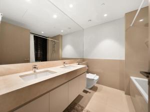 a bathroom with two sinks and a toilet at Wabi-Sabi Style Fountain-View 4 BR Apt in the Sky in Dubai