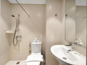 a white bathroom with a toilet and a sink at Wabi-Sabi Style Fountain-View 4 BR Apt in the Sky in Dubai