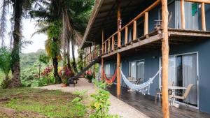 a house with a hammock on the side of it at Hotel Buenos Aires in Santa Teresa Beach