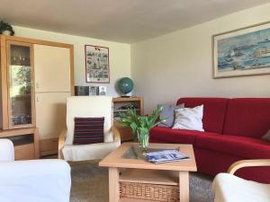 グリュックスブルクにあるFerienwohnung Valentinの赤いソファとテーブルのあるリビングルーム