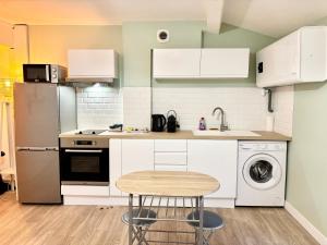 een keuken met witte kasten en een wasmachine en droger bij Confort & Cosy Proche centre ville in Valence
