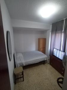 - une petite chambre avec un lit et une commode dans l'établissement Habitación cama grande doble 150 x190 TV wifi, à Alicante