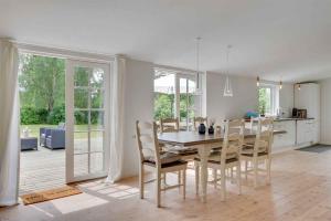 a kitchen and dining room with a table and chairs at Lovely Secluded Cottage In Dronningmølle in Dronningmølle