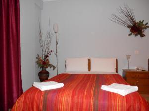 a bedroom with a bed with two towels on it at Hotel Vasilis in Nafplio