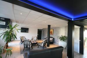Cette chambre est dotée d'une table, de chaises et d'un plafond bleu. dans l'établissement Hotel Air-lane, à Saint-Léger-sous-Brienne
