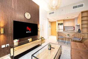 a living room with a tv on a wall at 1BR Signature Apartment in Sharjah in Sharjah