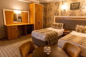 a hotel room with two beds and a table at Grand Rosa Hotel in Istanbul