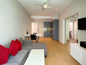 un soggiorno con un divano grigio e cuscini rossi di Coast Boutique Hotel a Kuta