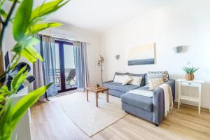 a living room with a blue couch and a window at Ribeira DIlhas Beach Apartment in Ericeira +21 photos