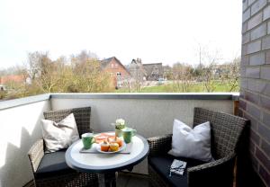 a table with a bowl of fruit on a balcony at Ferienwohnung de Hasel in Dorum Neufeld