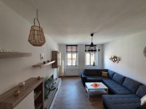 a living room with a blue couch and a table at Familienappartments- Fewo's Ahrend in Wernigerode