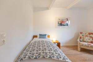 a bedroom with a bed and a chair at Dat Reethuus in Böhl