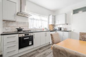 a kitchen with white cabinets and a wooden table at Serviced Accommodation Liverpool by Tomla- Free Parking in Liverpool