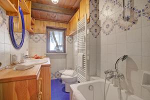 a bathroom with a tub and a toilet and a sink at Appartamento Beau Soleil - Happy Rentals in Sauze d'Oulx