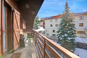 a balcony of a building with a christmas tree at Appartamento Beau Soleil - Happy Rentals in Sauze d'Oulx