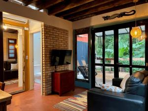 a living room with a couch and a tv at Casa Saíra in Bombinhas