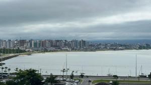 a large body of water with a city in the background at CASA CONCEITO - studio panoramico, suites e quartos in São José +84 photos