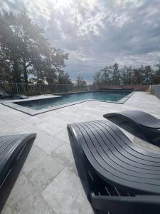 a swimming pool with a bench in front of it at Gîte de Combe Falce in Salignac Eyvigues