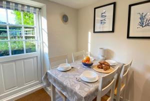 a dining room with a table and chairs and a window at Norfolk Chapel Cottages in Docking