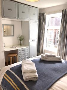 a bedroom with a bed with two towels on it at Norfolk Chapel Cottages in Docking +2 photos